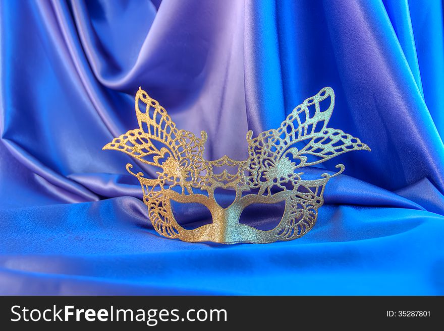 Carnival mask gold new year unisex against the background blue theater. Carnival mask gold new year unisex against the background blue theater