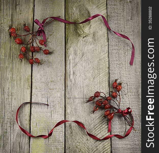 Vintage frame with berries and ribbons on wooden background. Vintage frame with berries and ribbons on wooden background