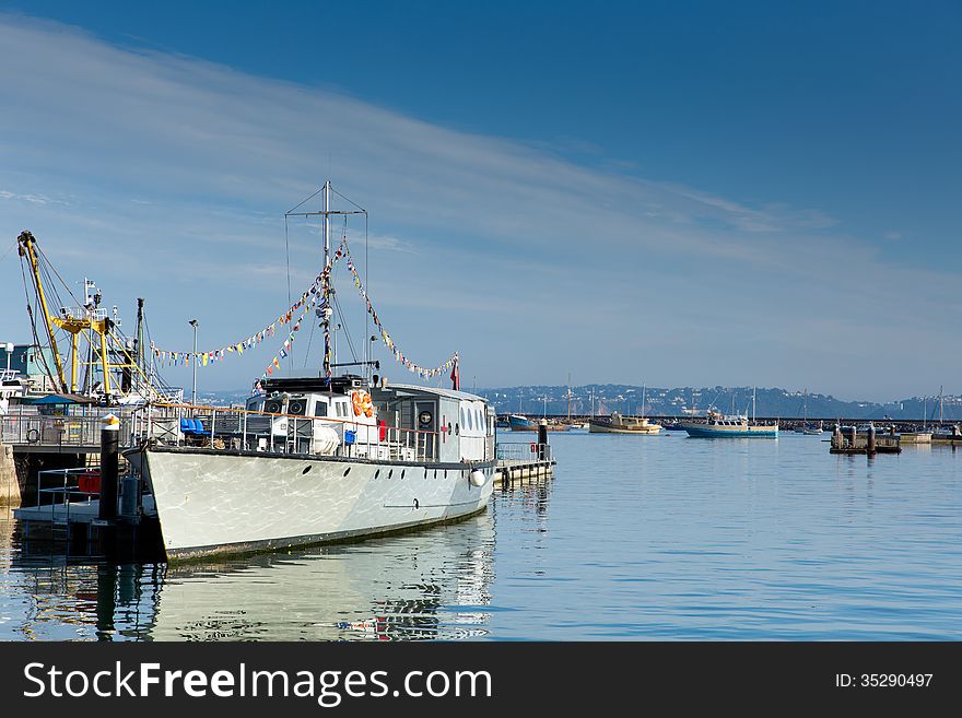 Brixham marina Devon with large boat and yachts Torbay England UK with blue sky and white cloud