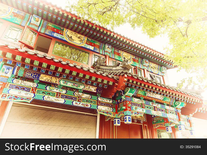 Chinese traditional construction roof with green tree leaves.