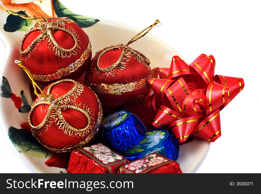 Chocolates and Christmas ornaments in a plate isolated on white. Chocolates and Christmas ornaments in a plate isolated on white