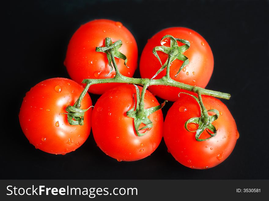 Bunch of tomatoes on a black background