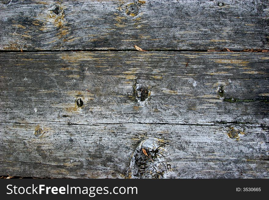 Old weathered wooden plank texture with knots and some debris. Old weathered wooden plank texture with knots and some debris.