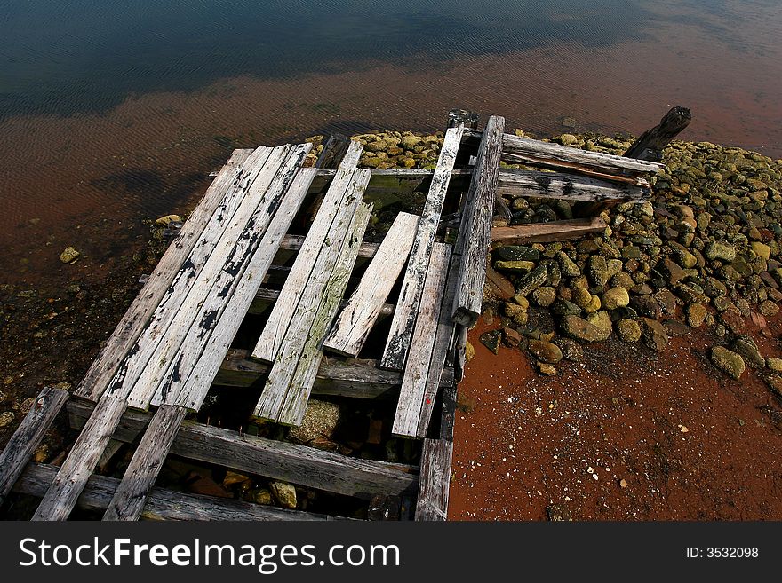 A old dock on red beach. A old dock on red beach