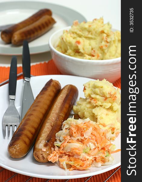 Large frankfurters with carrot and cabbage coleslaw and mash for dinner. Large frankfurters with carrot and cabbage coleslaw and mash for dinner