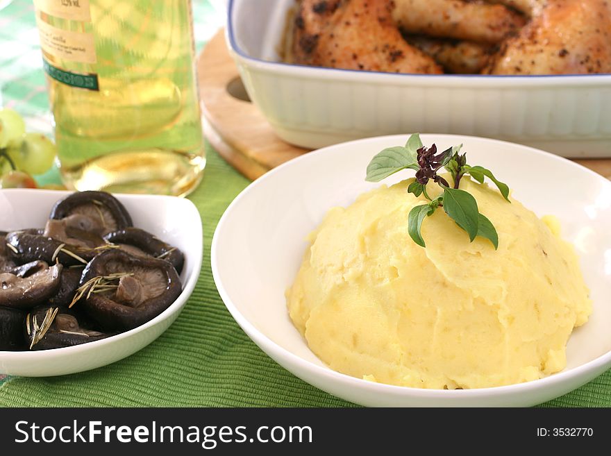 Mash potato with basil heaped up and smoothed off in a white ceramic bowl