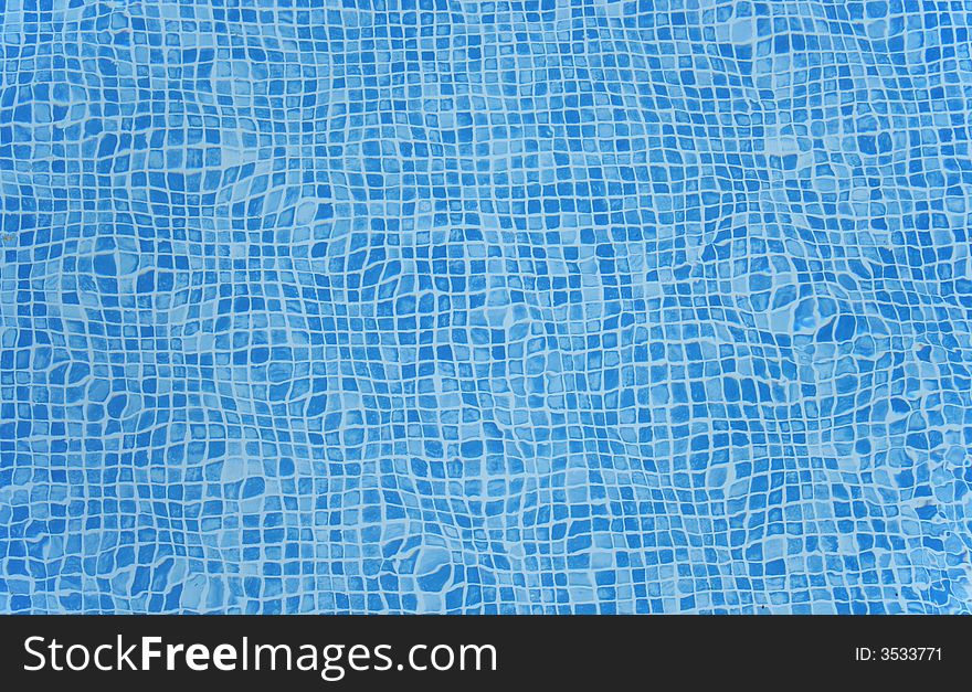 A view through the surface of water of the bottom of a swimming pool. A view through the surface of water of the bottom of a swimming pool