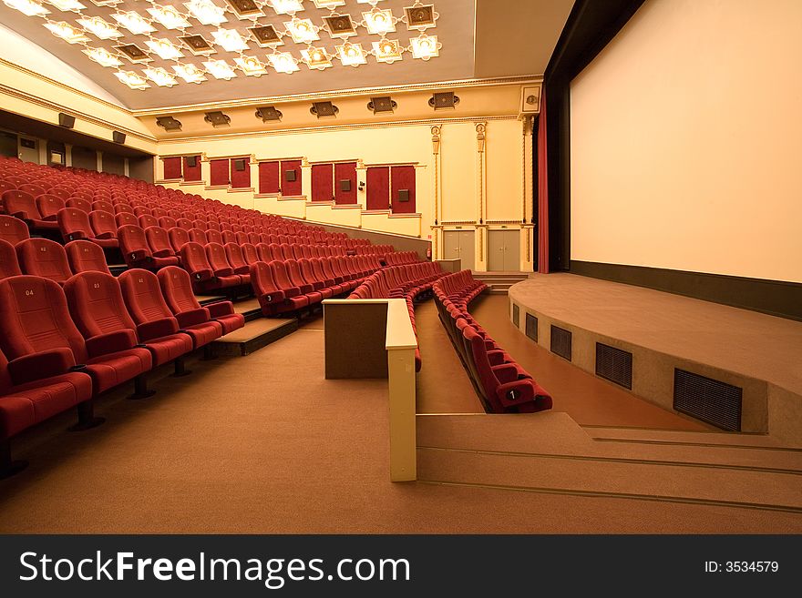 Empty cinema auditorium with red chairs