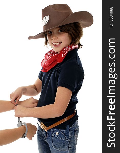 Elementary child playing cowgirl-sheriff handcuffing a culprit. Elementary child playing cowgirl-sheriff handcuffing a culprit.