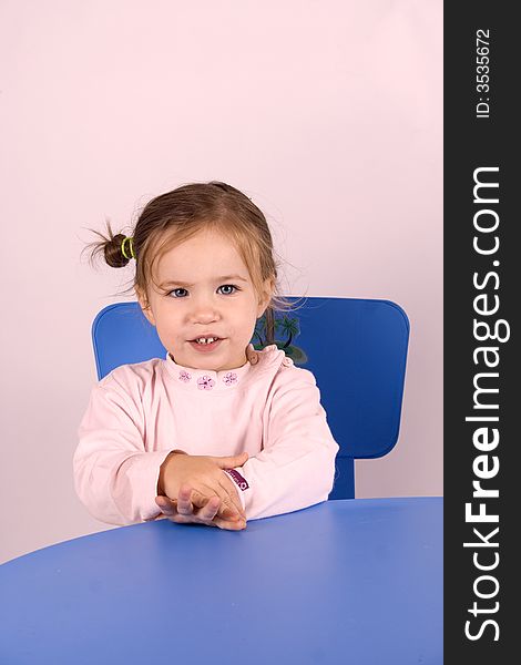 Little girl sitting on the chair and  playing