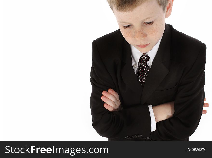 Little boy dressed in a suit looking down with serious expression. Little boy dressed in a suit looking down with serious expression