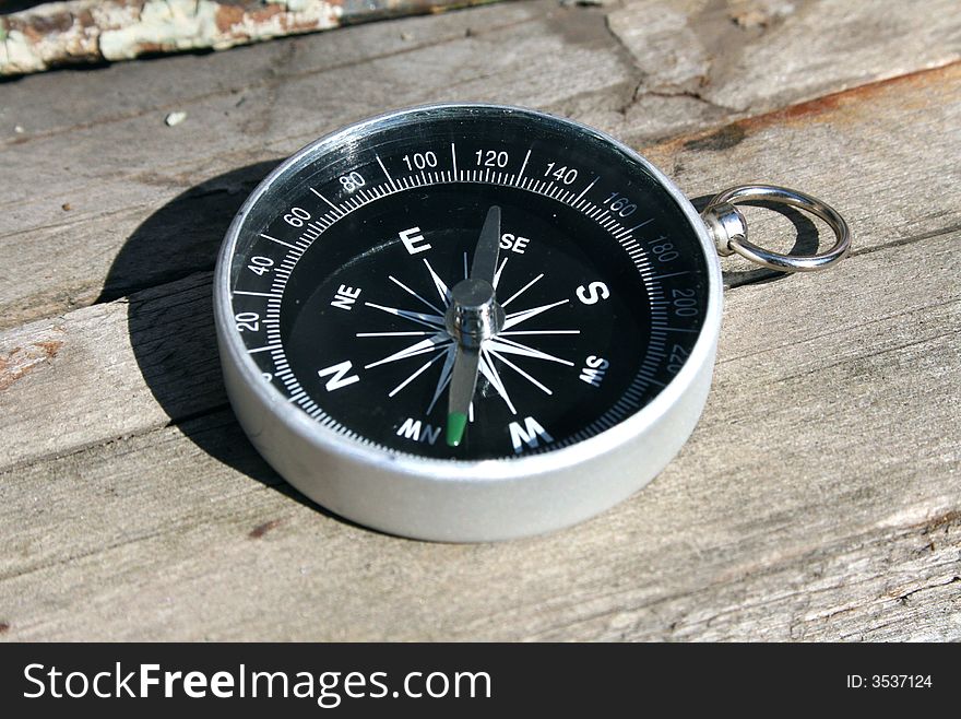 Compass on wood structure, in autumn light