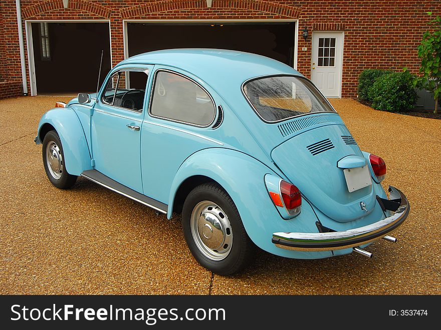 A small antique blue car. A small antique blue car.