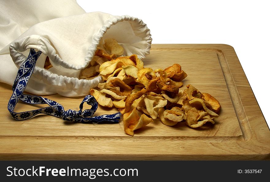 Bag of dried apple slices on wooden board