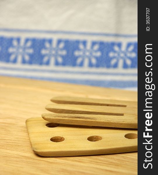 Wooden cutlery on wooden board with traditional background