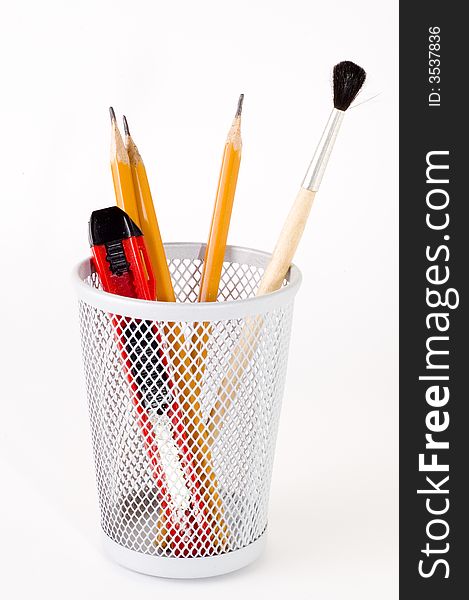 Pencil, paper knife and brush in basket holder