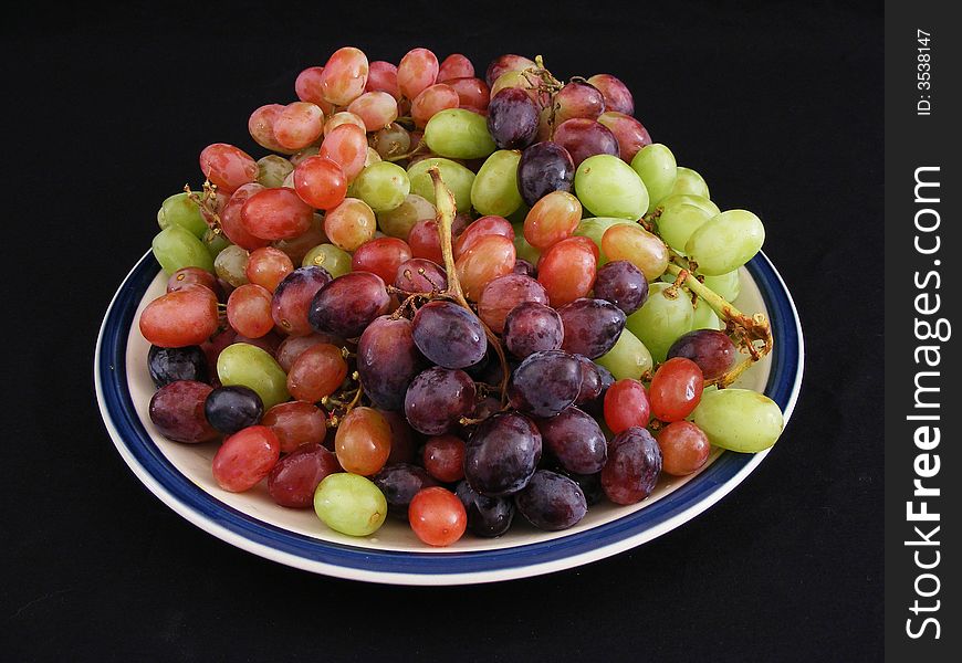 Profile of a pile of grapes against a black background. Profile of a pile of grapes against a black background.