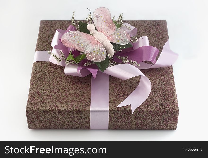 Many-coloured gift box with pink ribbon and butterfly isolated on white