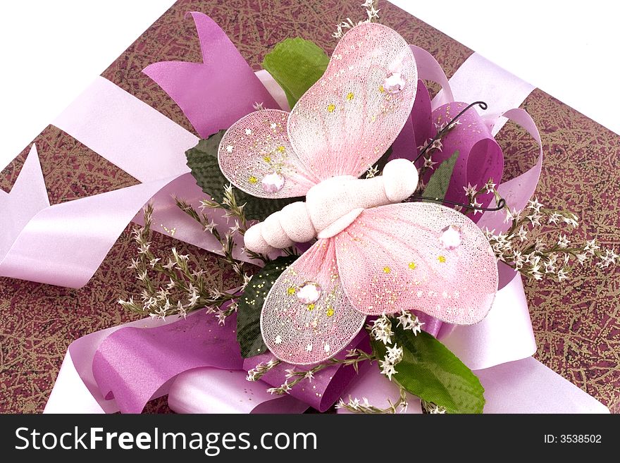 Many-coloured gift box with pink ribbon and butterfly isolated on white