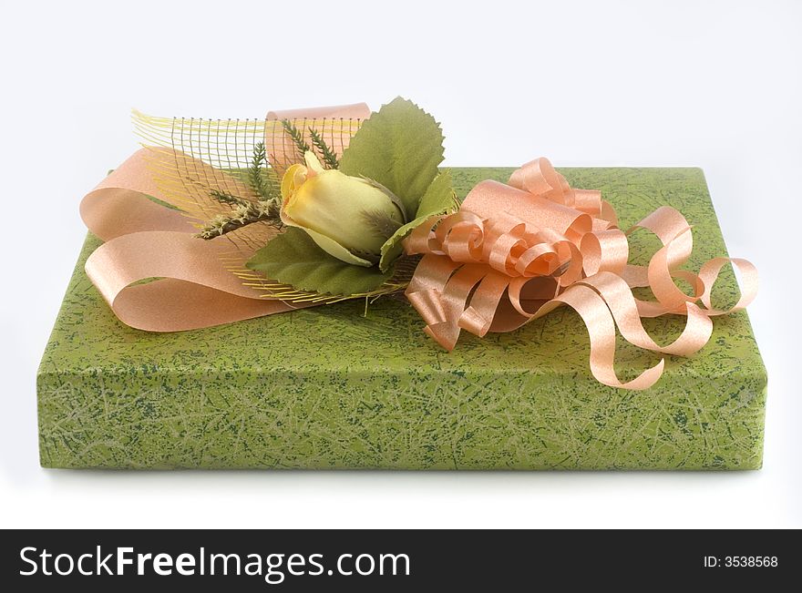 Green gift box with orange ribbon and flower isolated on white