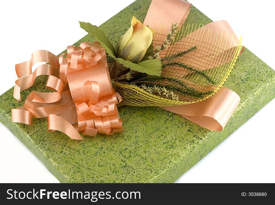 Green gift box with orange ribbon and flower isolated on white