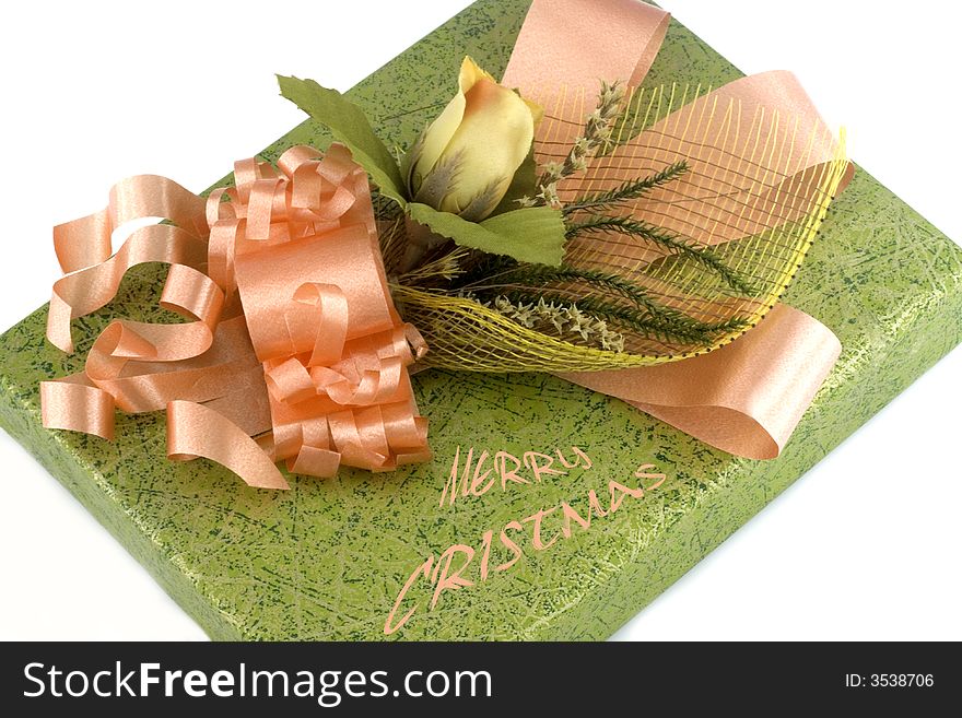 Green gift box with orange ribbon and flower isolated on white