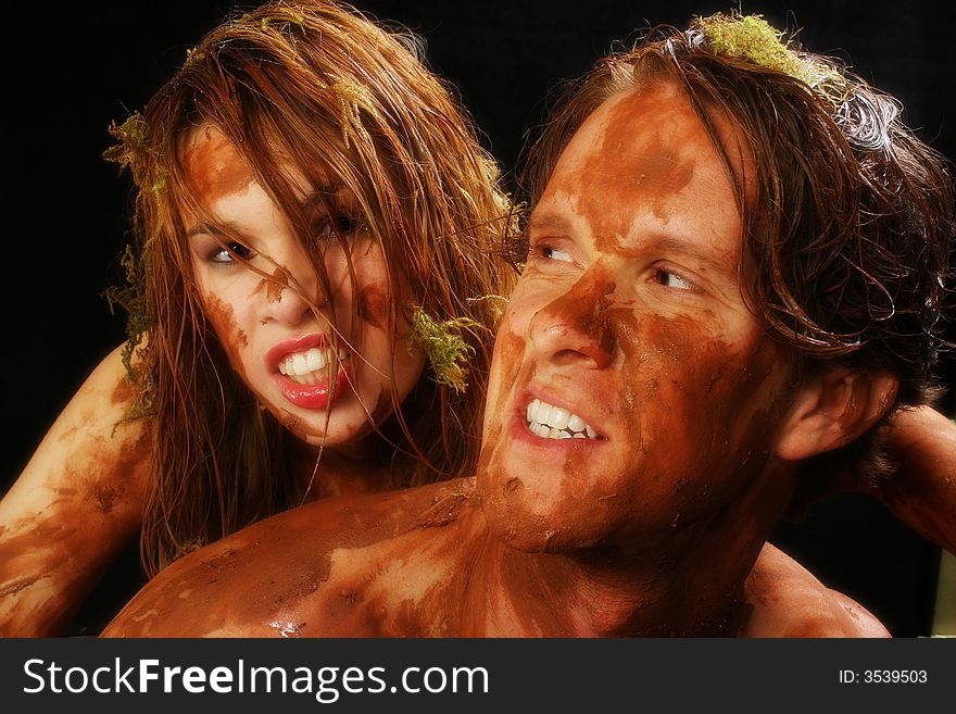 couple covered in mud, moss and water. couple covered in mud, moss and water.