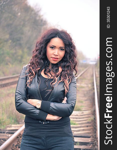 Portrait of an attractive young woman with long hair near railway. Portrait of an attractive young woman with long hair near railway.