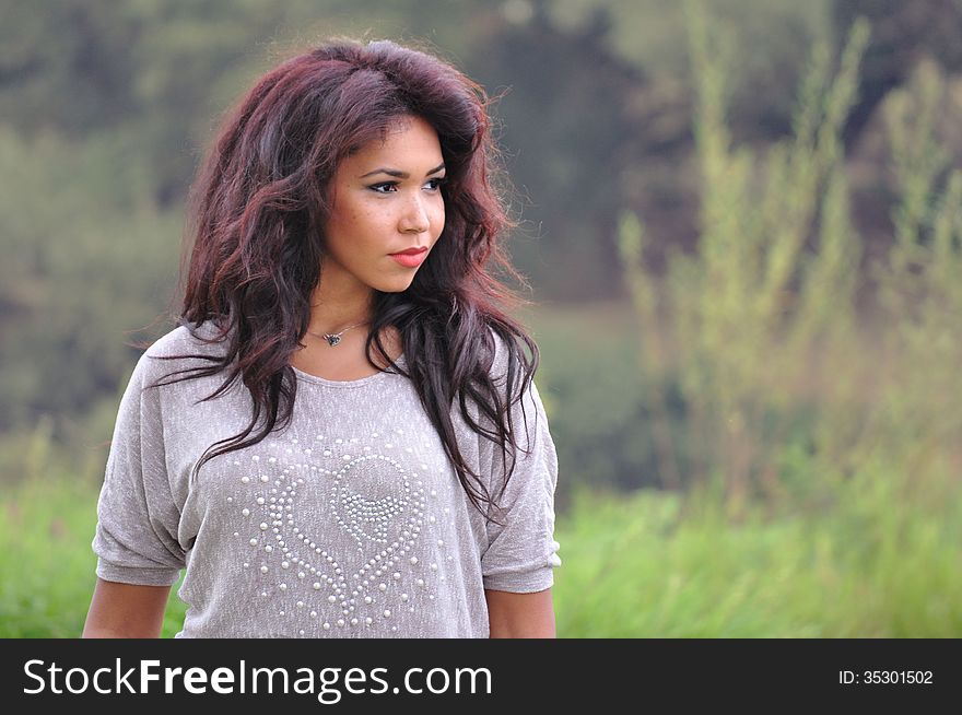 Outdoor portrait of an attractive young woman with long hair.