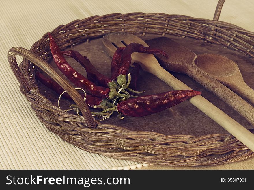 Dried red pepper on the background of a basket with spoons