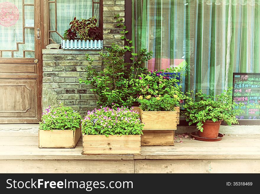 Flowers In Wooden Pot At The Store Entrance