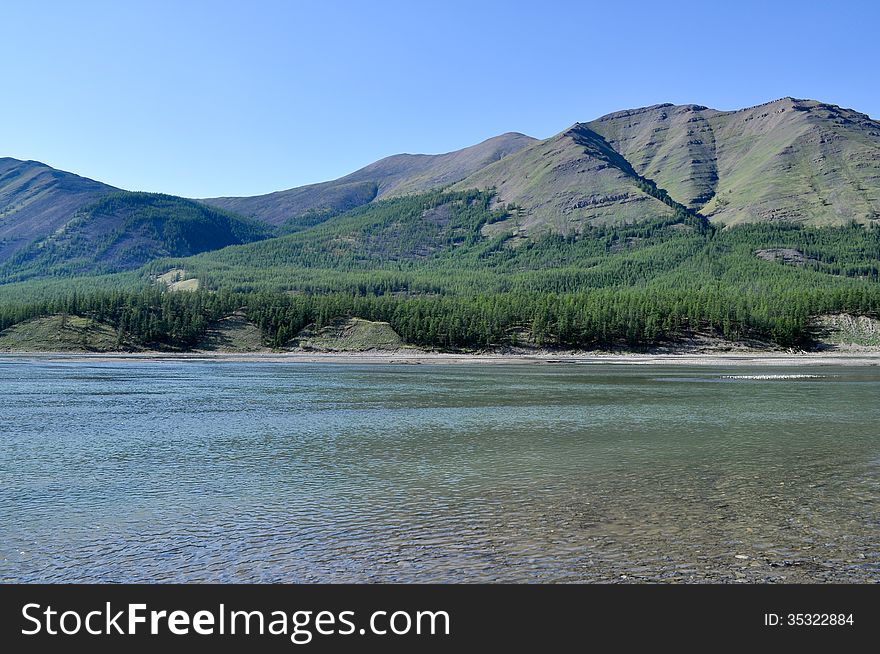 Sunny landscape of the river in mountains.