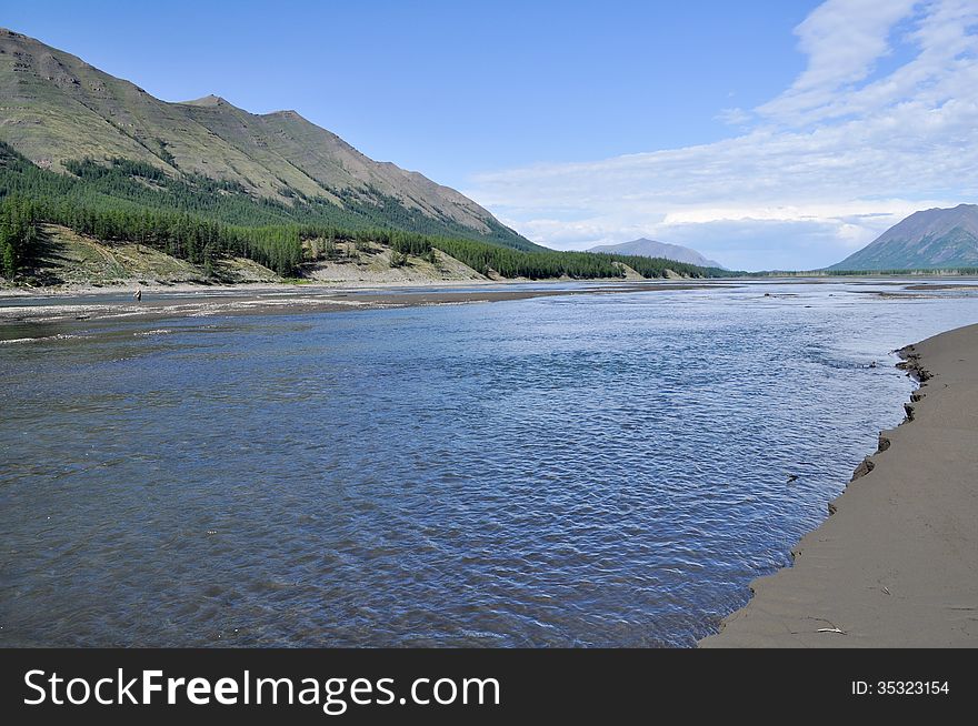Sunny landscape of the river in the mountains. Russia, Yakutia, Oymyakon highlands, a ridge of Suntar-khayata, river Suntar. Sunny landscape of the river in the mountains. Russia, Yakutia, Oymyakon highlands, a ridge of Suntar-khayata, river Suntar.