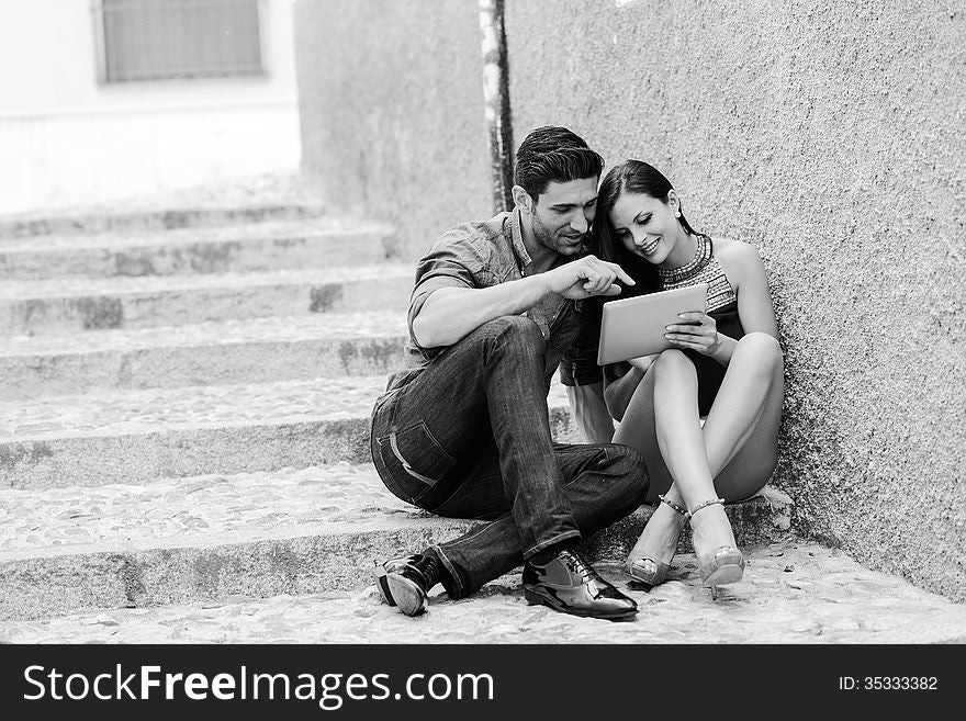 Portrait of beautiful couple with tablet computer in urban background. Portrait of beautiful couple with tablet computer in urban background