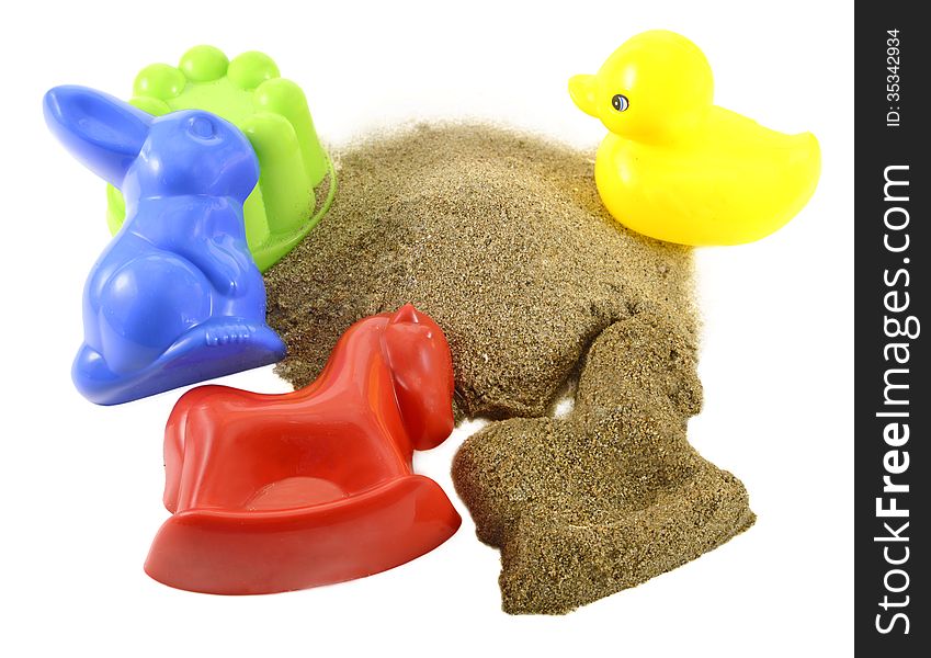 Colorful kids toys for sandbox with pile of sand isolated. Colorful kids toys for sandbox with pile of sand isolated