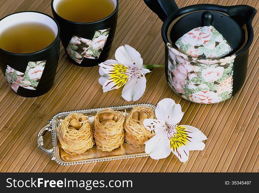 East sweets with teapot and cups and flowers