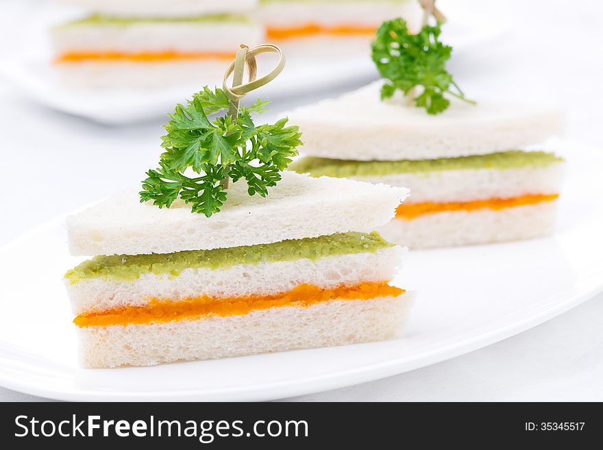 Vegetarian colorful sandwich with vegetable puree on the plate, close-up