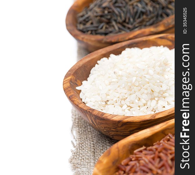 Wooden bowls with uncooked rice, selective focus, close-up, isolated on white