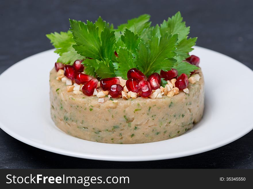 White bean pate with nuts and pomegranate on the plate