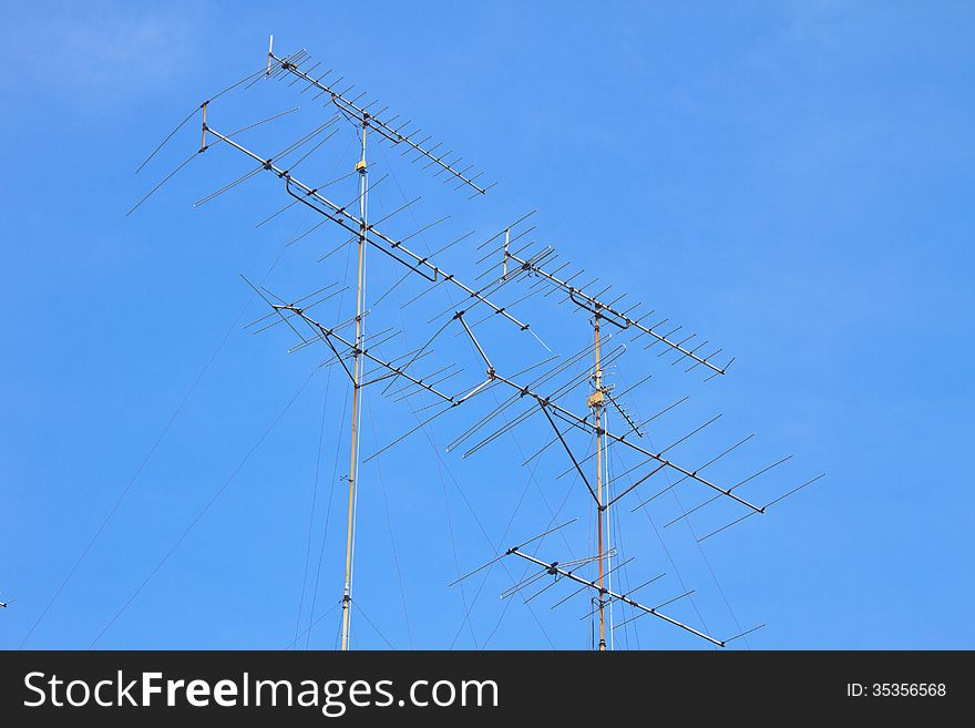 Television antenna on roof with blue sky