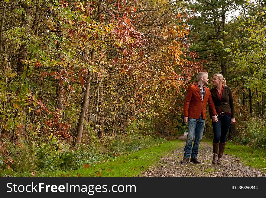 Happy Couple Is Taking A Walk In The Forest