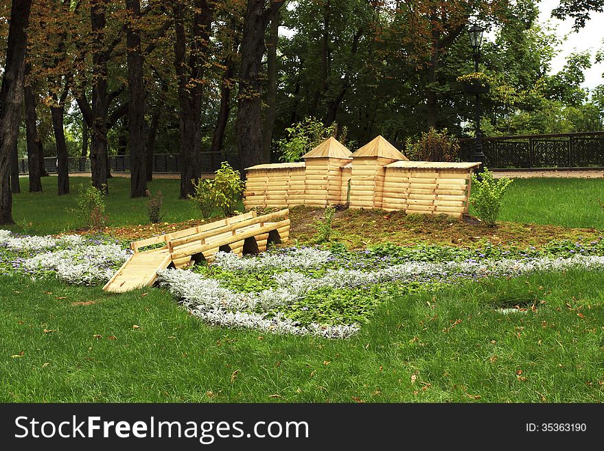 Bed with a wooden lodge for animals in city park. Bed with a wooden lodge for animals in city park