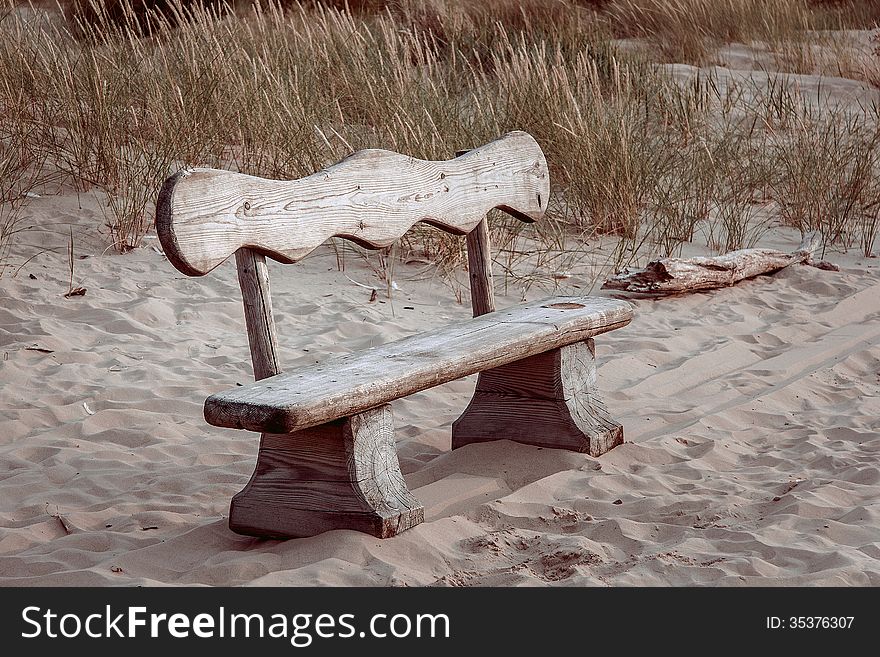 Bench in the dunes in beach in green grass