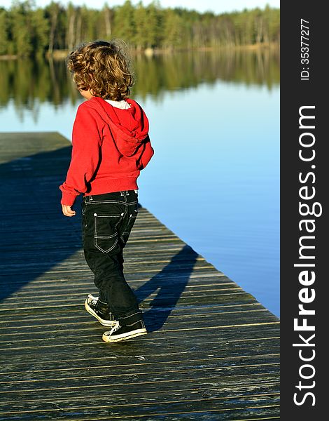 Kid playing in autumn sun by the lake. Kid playing in autumn sun by the lake