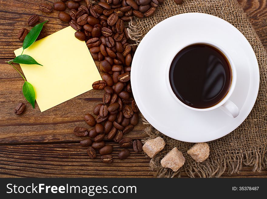 Cup of warm coffee, beans on wooden surface. Free space for your text. Cup of warm coffee, beans on wooden surface. Free space for your text