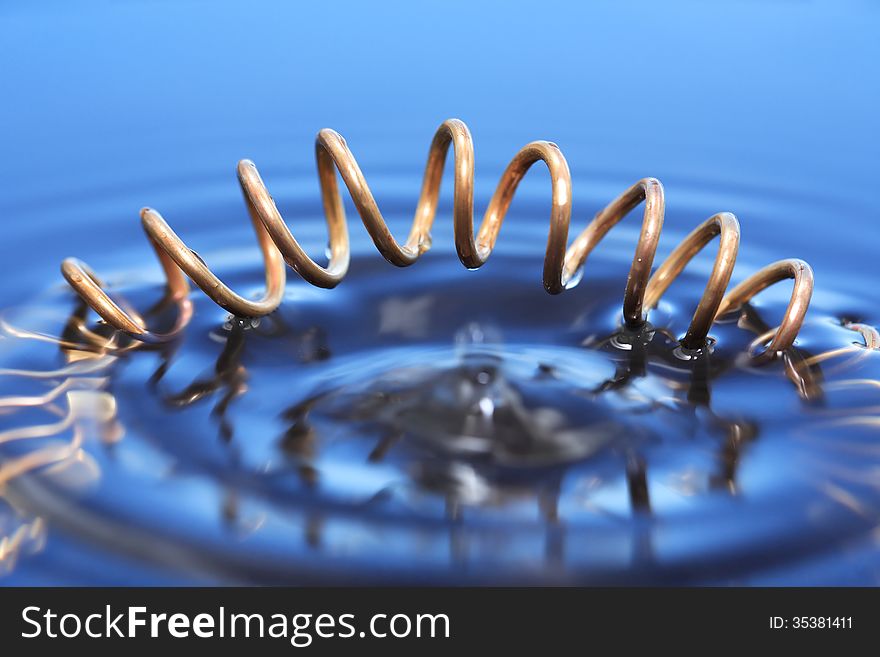 Abstract composition with copper spiral in blue water. Abstract composition with copper spiral in blue water