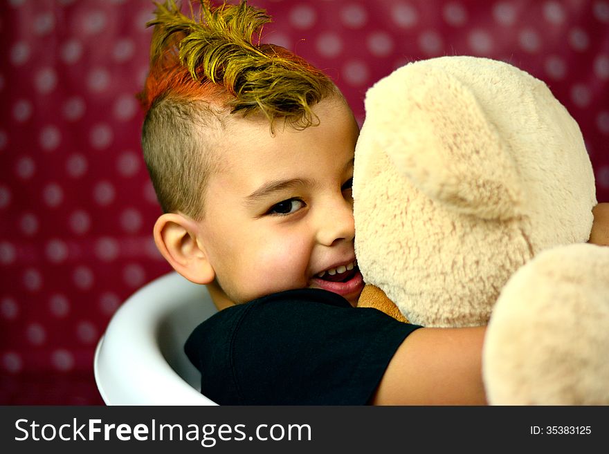 Boy hugging teddybear and smiling