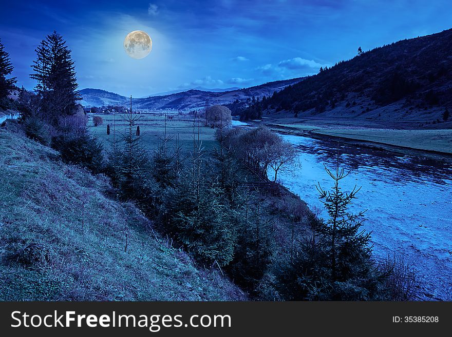 River flows by rocky shore near the autumn mountain forest