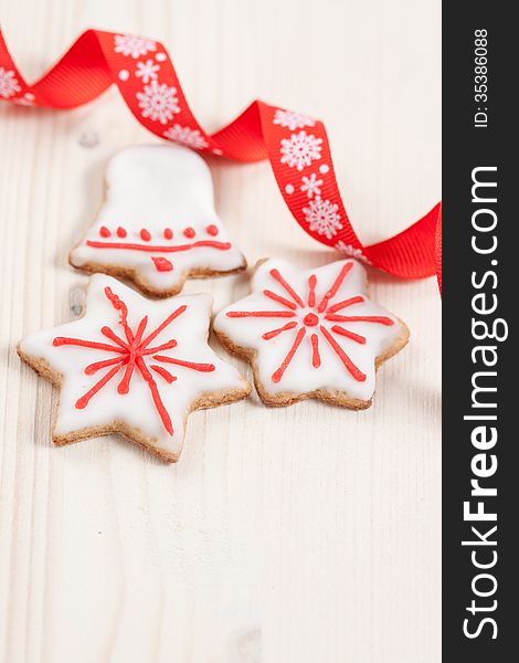 Christmas cookies in a white and red glaze on a white wooden background