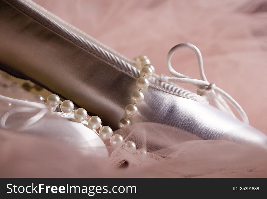 Pearls and white ballet shoes on ruffles